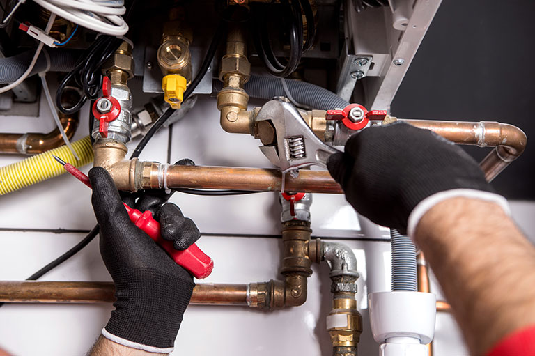 plumber fixing central heating system - THE HYDE NW9